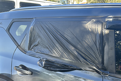 Side Window Covered with Plastic While Riverview Owner Is Deciding Where to Get Mobile Auto Glass Repair Services