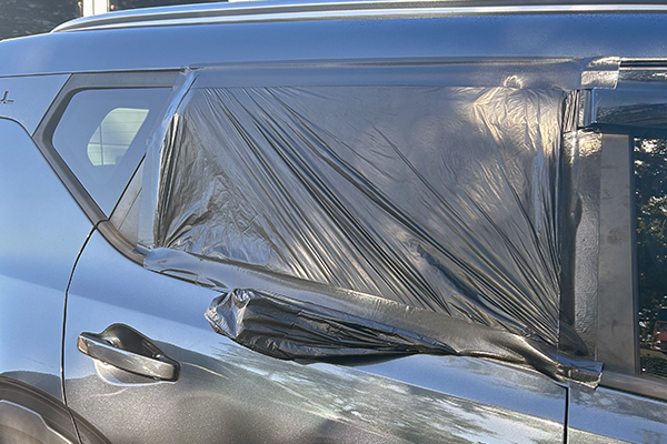 Side Window of a Car in Riverview Florida Covered With Plastic To Hide Damage